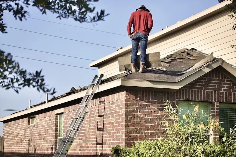 Professional roofer working on a residential roof in Grosse Pointe Village